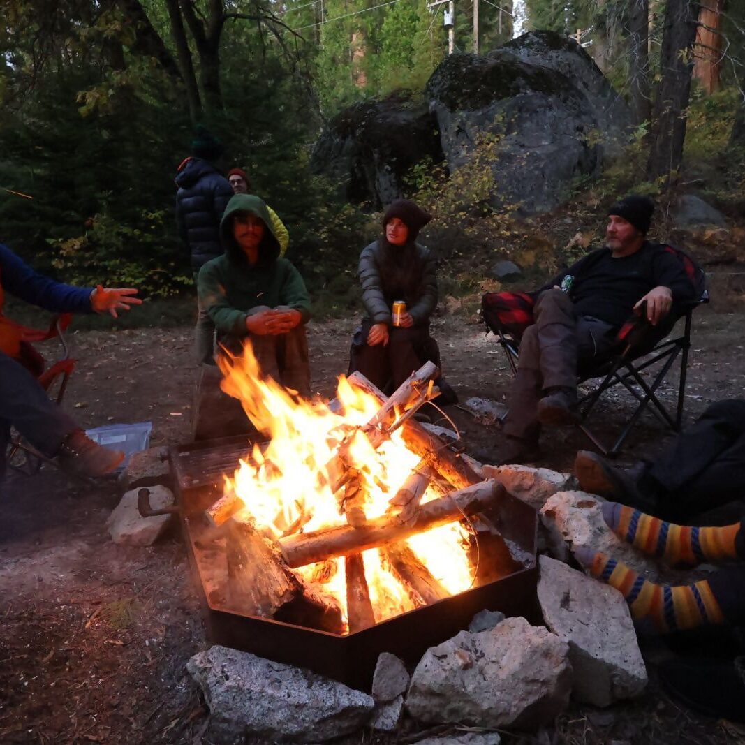 Group gathered around a campfire in nature.